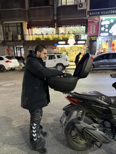 Usta, motorun arka çantasından aletlerini alıyor