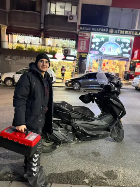Çilingir ustası, motorunun yanında alet çantasıyla